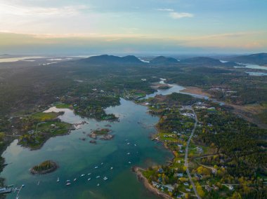 Bass Limanı ve köy hava manzarası gün batımında Acadia Ulusal Parkı 'ndaki dağlarla birlikte Maine ME, ABD' deki Çöl Adası 'ndaki Tremont kasabasının arka planında.. 