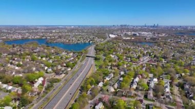 Arlington Heights suburban landscape aerial view in spring with Spy Pond and Boston modern city skyline at the background in historic town of Arlington, Massachusetts MA, USA. 