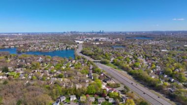 Arlington Heights suburban landscape aerial view in spring with Spy Pond and Boston modern city skyline at the background in historic town of Arlington, Massachusetts MA, USA. 