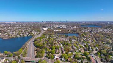 Arlington Heights suburban landscape aerial view in spring with Spy Pond and Boston modern city skyline at the background in historic town of Arlington, Massachusetts MA, USA. 