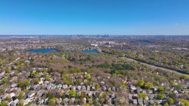 ABD 'nin Massachusetts MA, Arlington kentinin arka planında Spy Pond ve Boston modern şehir siluetinin yer aldığı Arlington Heights banliyö manzarası. 
