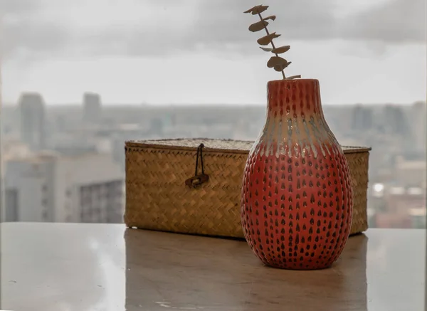 在漂亮的陶瓷红色花瓶中烘干的花朵 手工制作 用梭织藤条传统盒装在大理石桌子上的客厅和城市景观 家居装饰 文字空间 有选择的重点 — 图库照片