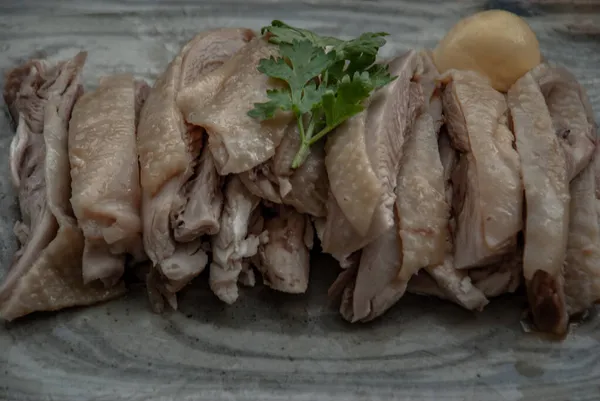 Close-up of Asian food style marinated steamed chicken (Betong Chickken) and sauce on ceramic plate. Serving chilled as an appetizer.