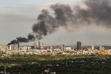 Bangkok, Tayland - 10 Ekim 2021: Yanmış endüstriyel ya da iş yeri binalarından çıkan duman bulutları şehrin bir bölgesinde yanmakta. Yangın kazası, seçmeli odaklanma.