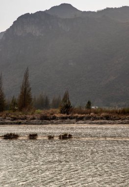 Dağ manzarası. Büyük bir dağ nehirle çevrilidir. Tam olarak odaklanamıyorum..