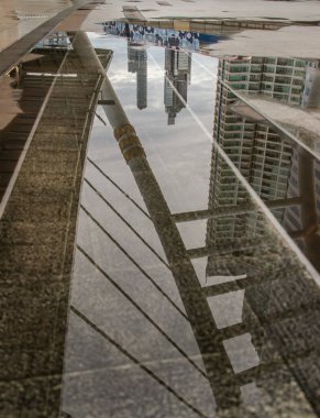 Köprü yapısının, binaların ve gökyüzünün yansımaları gökyüzündeki yağmur suyu birikintisinin üzerinde Chong Nonsi istasyonundaki gökyüzü tren istasyonuna kadar uzayı kopyala, seçici odak noktası.