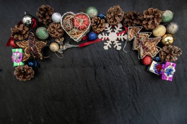 Geniş kemer şekilli Noel dekorasyon kenarı. Dal dalları, kahverengi kozalaklar ve koyu arkaplanda çeşitli meyveler olan Xmas geyiği. Üst Görünüm, Boşluğu Kopyala.