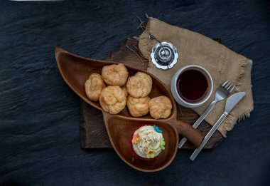 Kahvaltı vakti geldi. Choux kremalı kek ve ahşap arka planda çay. Üst görünüm.