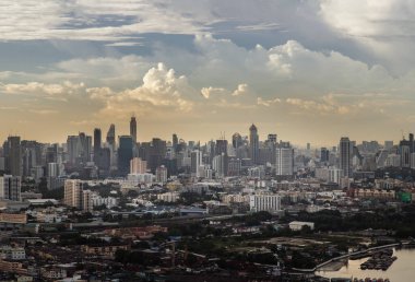 Bkk, Tayland - 31 Haziran 2021: Gökdelen akşam saatinin güzel manzaralı havadan görünüşü ve Köprü alacakaranlıkta parlayan ışıklarla Chao Phraya Nehri 'ni geçer. Tam olarak odaklanamıyorum..