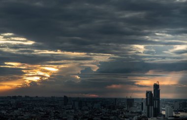 Bangkok, Tayland - 29 Ağustos 2021: Bangkok 'taki büyük metropol şehri üzerinde turuncu ve mavi gökyüzü bulutlu güneşin doğuşunun ya da batışının muhteşem manzarası. Uzayı kopyala, özellikle odak yok..