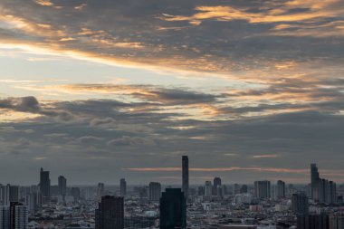 Bangkok, Tayland - 12 Şubat 2021: Bangkok 'taki büyük metropol şehri üzerinde turuncu ve mavi gökyüzü bulutlu gündoğumunun ya da batımının muhteşem manzarası. Uzayı kopyala, özellikle odak yok..