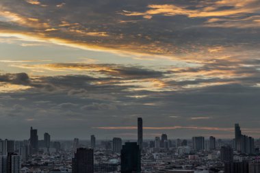 Bangkok, Tayland - 12 Şubat 2021: Bangkok 'taki büyük metropol şehri üzerinde turuncu ve mavi gökyüzü bulutlu gündoğumunun ya da batımının muhteşem manzarası. Uzayı kopyala, özellikle odak yok..