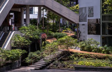 Bangkok, Tayland - 16 Nisan 2021: Beton merdiven ve çevredeki yeşil ağaçlar alışveriş merkezindeki otoparkta. Tam olarak odaklanamıyorum..