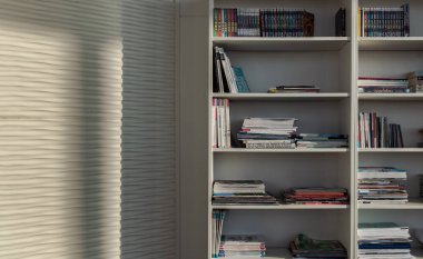 Bangkok,Thailand - Jan 10, 2022 : Library of shared facility at living room of home condominium. Different books are arranged on a white bookshelf, Selective focus.