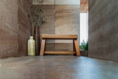 Kentsel ahşap bir terasta rahatlatıcı bir köşe. Yakınlarda kurumuş çiçekli iki ahşap vazo ve seçici bir odak noktası olan tahta bir bank..