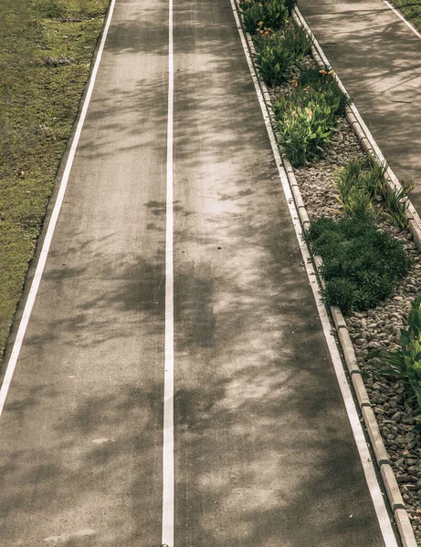 中间环绕着绿草的中间带的空旷道路纹理的顶部视图 有选择的重点 — 图库照片