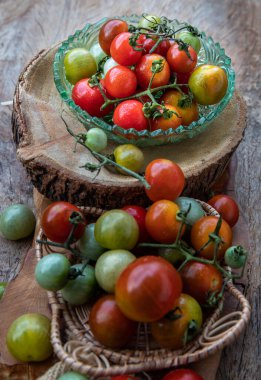 Eski ahşap arka planda Taze Yaban Domatesleri (Mini Kiraz Domatesleri) grubu. Seçici odak.