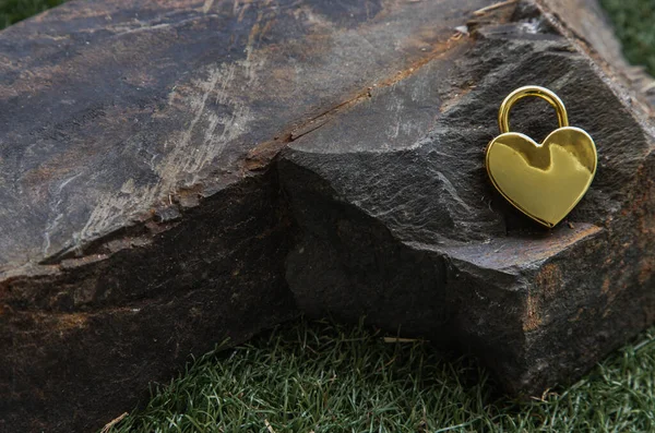 草の背景に巨大な石の上に黄金のハート形の愛南京錠 バレンタインデーのコンセプト コピースペース 選択的フォーカス — ストック写真