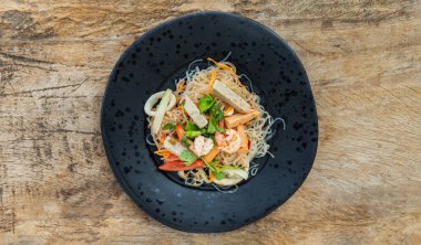 Baharatlı cam erişte salatası veya taze deniz ürünleri (Yum woon sen) ile baharatlı lezzetli Mung fasulyeli erişte salatası ahşap masa. Baharatlı vermicelli salatası, sebzeler ve otlar, ekşi ve baharat, Tayland mutfağı, seçici odaklanma.