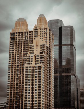 Bangkok, Tayland - Nisan 02, 2022: Üst üste binaların mimari görüşü, üst üste binaların tekrarlanan yapı camları ve yansımaları. Modern binaların tasarımında açısal geometrik, özellikle odak noktası yok..