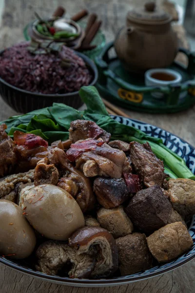 炖肉腿 煮熟的鸡蛋 豆腐和Kale在陶瓷碗里 配上李子饭和中国茶 放在旧木桌上 复制空间 没有焦点 特别是 — 图库照片