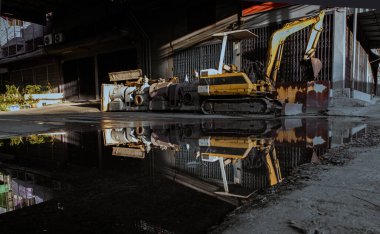 Bangkok, Tayland - 23 Nisan 2022: Sarı renkli inşaat kazısı ve suyu yansıtan eski su pompaları. Yapı Ekipmanı, Seçici Odaklanma.