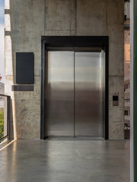 Elevator Chrome Metal Closed Door Bare Cement Wall Lifting People — Stok fotoğraf