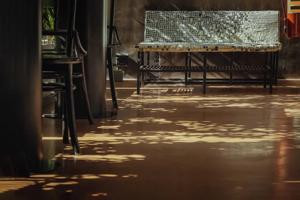 Güzel güneş ışınları boş kafe yaz terasında parıldıyor. Alçıda klavye tuşlarından yapılmış çelik sandalye tasarımı var. Boşluğu kopyala, Seçici odak.