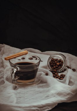 Şeffaf bir bardakta iki kat kahve, altında Espresso kahvesi ve taze süt ile Tayland tatlısı çıtır çıtır çubuk, yanında da beyaz arka planda kavrulmuş kahve çekirdeği. Kahve molası, seçici odak.