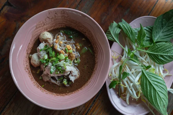 Thin rice noodles in thicken soup added blood with Pork balls, Sliced pork, pork liver sprinkle with Sliced spring onion (Nam tok small noodles) Serve with basil and bean sprouts. Thai Boat noodles soup or Guay tiew reua is Thailand\'s most famous noo