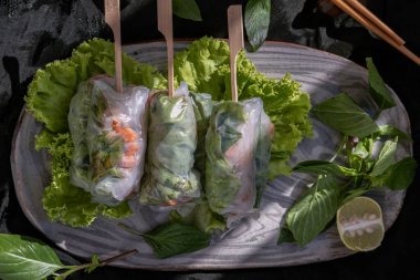 Sağlıklı Vietnam börekleri, porsiyon olarak seramik tabakta sebze olarak sunulur. Üst Görünüm, Seçici Odaklanma.