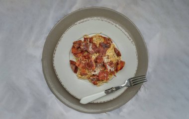 Kızarmış pastırmalı mantarlı carbonara spagettisi ve seramik tabakta rendelenmiş peynir. İtalyan mutfağı, Üst Görünüm, Kopyalama alanı, Seçici Odak.