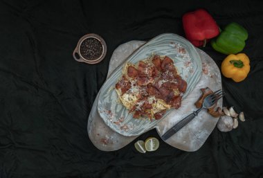 Kızarmış pastırmalı mantarlı carbonara spagettisi ve seramik tabakta rendelenmiş peynir. İtalyan mutfağı, Üst Görünüm, Kopyalama alanı, Seçici Odak.