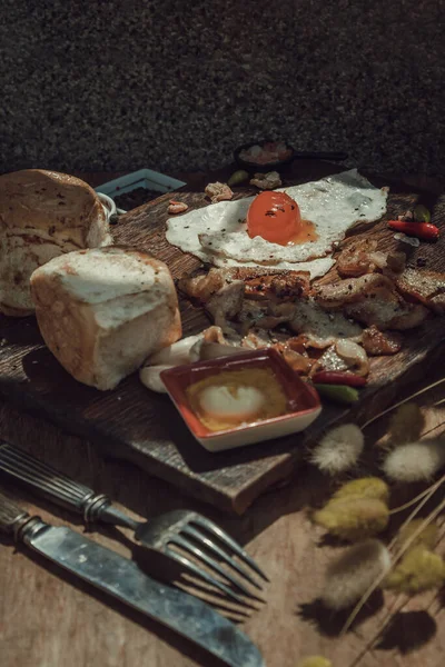 Kızarmış yumurta, kızarmış domuz pastırması ve ballı ekmek ile ahşap kesme tahtasında servis edilen ev yapımı kahvaltı. Sağlıklı gıda konsepti, Seçici Odaklanma.
