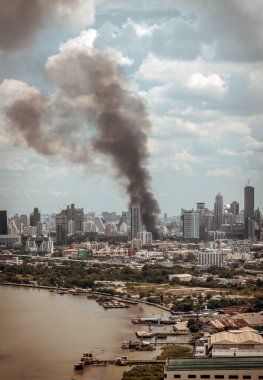 Bangkok, Tayland - 21 Haziran 2022: Bangkok 'ta yanan binadan çıkan siyah duman bulutları. Yangın kazası, özellikle odaklanmadan..
