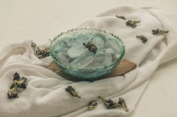 新鲜的棕榈配上蓝蝴蝶豌豆糖浆和装饰有干蝴蝶豌豆花的刨冰 放在白色背景的玻璃碗里 传统的泰国甜点 有选择的焦点 — 图库照片