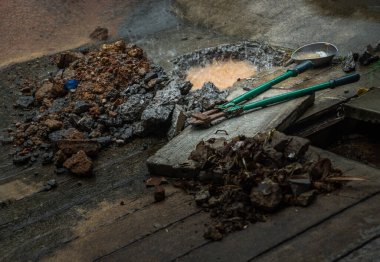Kırık su borusu yağmur sırasında evin önünde patladı. Eski beton ve molozların üzerindeki cıvata keskisi ile yerde görülebilir bir delik, tesisat onarımı, özellikle odak yok,.