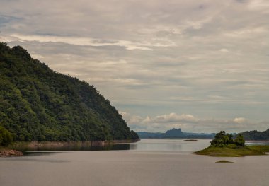 Natural scenery of water in reservoirs and dam with sky and mountains range in background. Copy space, Selective focus.