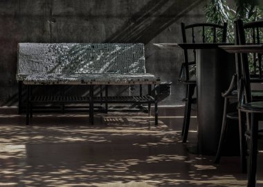 Bangkok, Thailand - Apr 29, 2022 : Beautiful sun rays light shining through Empty cafe summer terrace with design chair made of keyboard keys on plaster. Copy space, No focus, specifically.