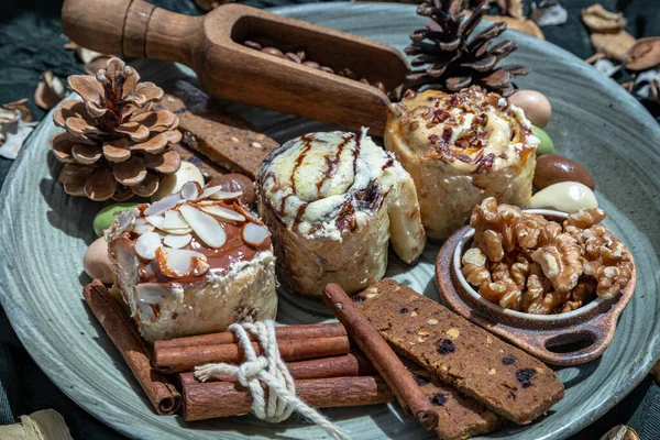 Bakery, Stick cookies, Walnuts and Colored eggs with Pine cones on Ceramic plate. Easter desserts, Selective focus.