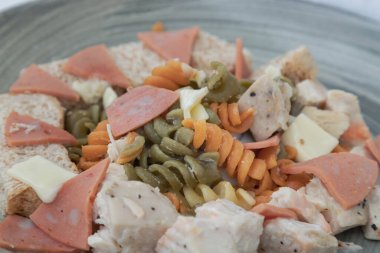 Seramik tabakta Peynirli, Sosisli ve Ekmekli Karidesli Fusilli. Seçici Odaklanma.