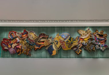 Bangkok, Tayland - 30 Sep 2022: Duvarında dekoratif el sanatları ve sanat eserleri olan geleneksel Tayland tekstil renklerinin sanatsal çeşitliliği. Eski Tayland kumaşlarının çeşitli renkleri, odak yok, spesifik