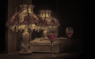 Aynadaki şarap kadehinin yansıması ve masadaki Vintage gece lambasının loş ışığı. Çok romantik, Aydınlık ve Gölge, Karanlık ton, metin için boşluğu kopyala.
