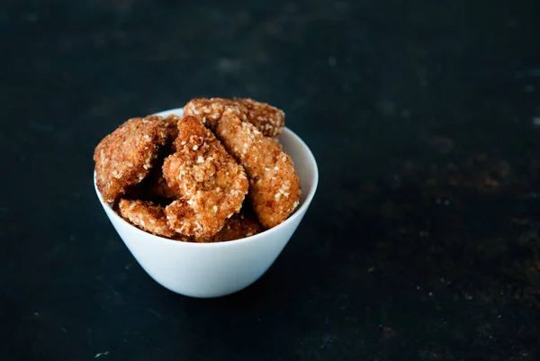 Zelfgemaakte kipnuggets met ketchup op een zwarte tafel, bovenaanzicht, kopieerruimte. Fast food concept. Kippenvlees Rechtenvrije Stockfoto's