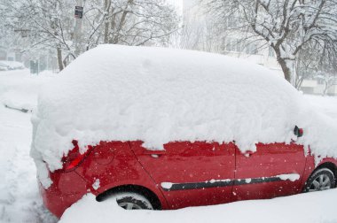 Bir apartmanın avlusunda kışın karda bir araba. Araba için kişisel bir garaj olmaması sorunu. Makineden kar kaldırma, şiddetli kış.