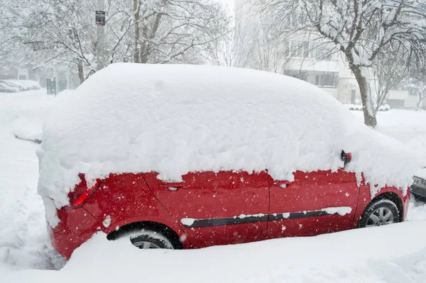 Een auto in de sneeuw in de winter op de binnenplaats van een appartementencomplex. Het probleem van het ontbreken van een persoonlijke garage voor de auto. Sneeuw verwijderen uit de machine, strenge winter Rechtenvrije Stockfoto's