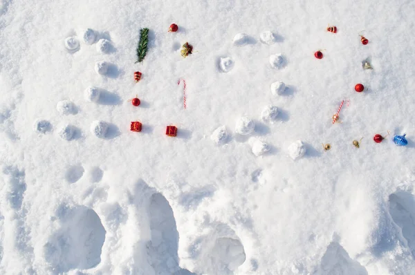 Iscrizione 2022 sulla neve fatta di palle di neve, palle di Natale, bastoncini dolci e stelle. Concetto durante anno nuovo, Natale, vacanze invernali, regali Foto Stock