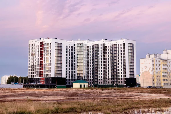 Modern residential area at sunset late in the evening. Late fall. Mud and puddles on the edge of the city. Multi-storey residential buildings. Mortgage for young families