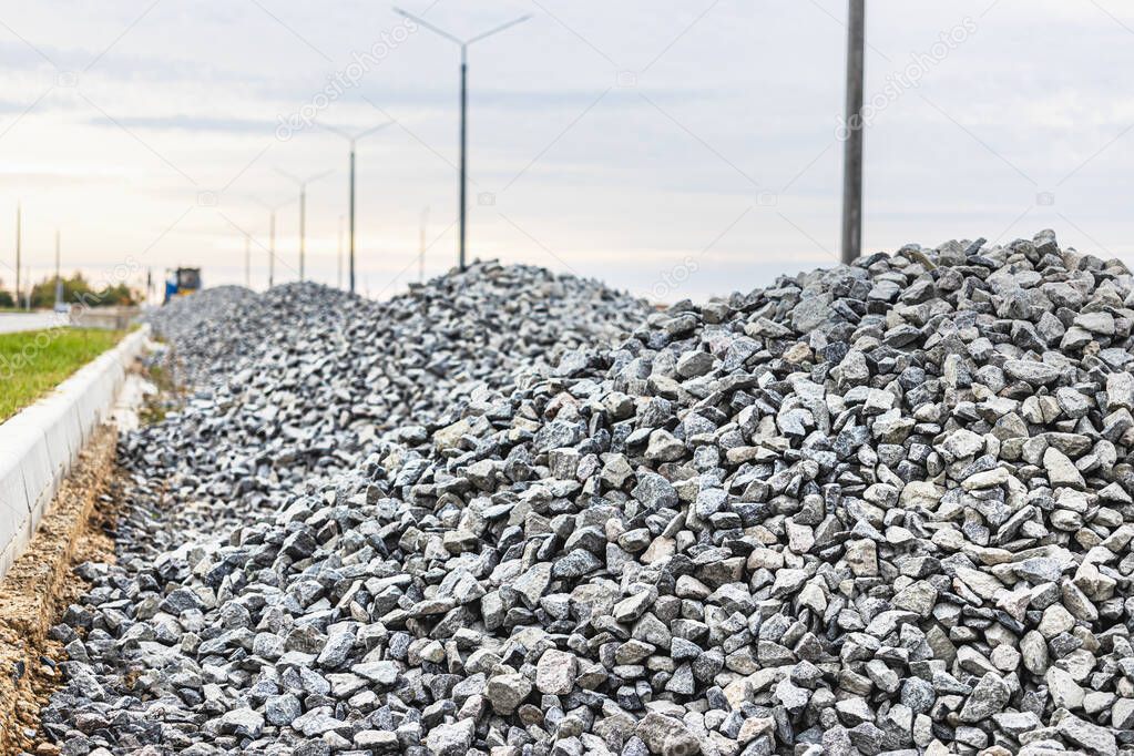 Industrial background with pile of gravel. Extraction of gravel. Construction of roads. Piles of gravel on construction site