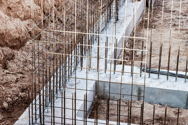 Monolithic foundation with metal reinforcement. Forms vertical formwork structures for the basement of a residential building. Monolithic concrete foundation. Support foundation. Home construction